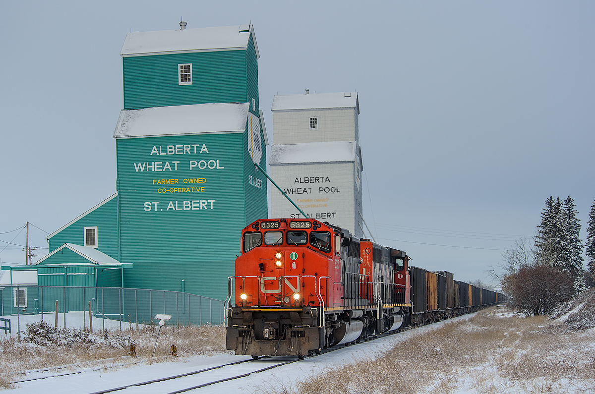 CN SD40-2Ws 5325 and 5279 had their work cut out for them last night, hauling 74 loaded gravel cars from Whitecourt into Edmonton. Here, they're seen passing the grain elevators at Mile 5 of the Sangudo Sub, St. Albert.