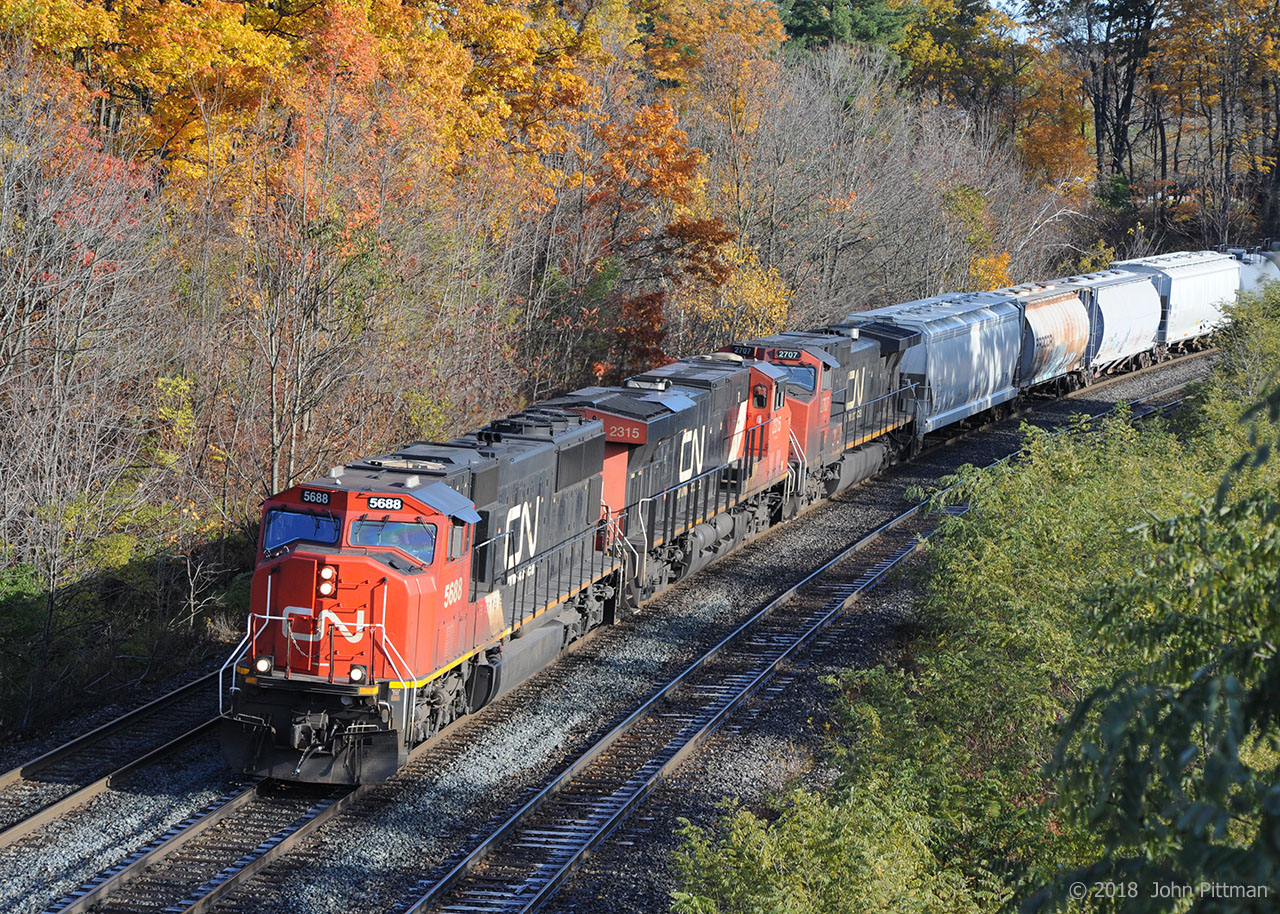 CN train 421 is powered by an SD75i, ES44ac, and Dash 9-44CW, on the first day back to Standard Time. Fall colours are well advanced, with many leaves fallen. There is frost on the shaded part of the ties.
The engines are approaching the signal for CN Bayview (Junction) as the train continues its departure from Aldershot Yard at CN Snake, with over half the train still rolling out of the yard.
CN 421 goes to Port Robinson Yard; on this day it is following VIA train 97 the "Maple Leaf", Amtrak equipment en route to New York City via Niagara Falls.