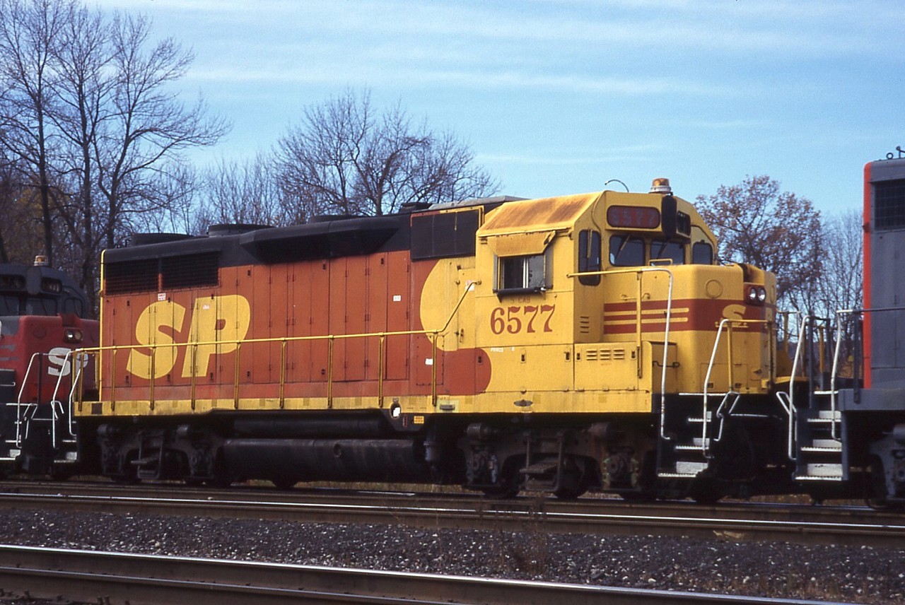 All the excitement over the "SP" on the GEXR made me think of another time some SP were in Southern Ontario.  Long before the days of e-mail, discussion groups and texting, imagine our surprise when 392 rounded the curve at Hamilton West with CN 9666, CN 9409, GTW 5929 and SP GP35s 6677, 6639, 6577 and 6556 in a cloudy of brake shoe smoke.  we hightailed it to King Road in Aldershot for another look.  For rebuild fodder the GP35s were in surprisingly good shape.  Of particular interest was 6577 in the red and yellow "kodachrome" scheme for the failed SPSF merger.  SPSF, meant to be the merger of Southern Pacific and Santa Fe; the acronym became "shouldn't paint so fast" after the ICC did not approve the merger.  Just as well, it would have been the Penn Central of the west.  It appears as though not all of these GP35s were rebuild, however SP 6577 was rebuilt at AMF in Montreal and lives on today as New Brunswick Southern (NBSR) 9803.  Thanks Dad for driving us all over creation to see this stuff!