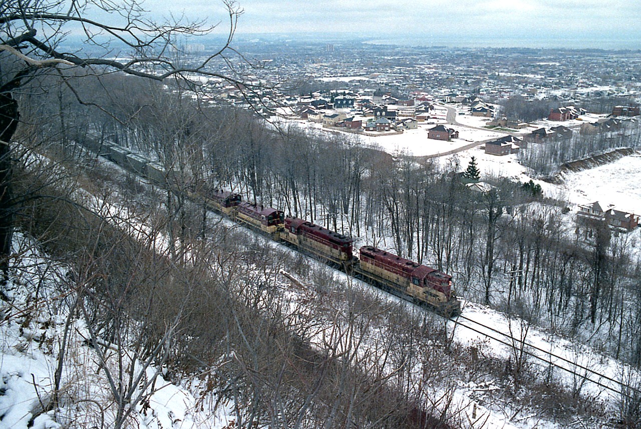 Getting a decent photograph of any train climbing the escarpment from Hamilton to Vinemount is always difficult. But still worth a try.  I'm not exactly sure where along the ridge I shot this from but I have a feeling it is just west of DeWitt Rd in the Creek. I doubt there is  a single building lot left down at the bottom of the hill, either. In the misty background once can see the beach strip and Burlington on the far side. Power on what I have listed as a rock train is TH&B 72, 73, 57, 51 and 55. Upon cresting the escarpment, TH&B 55 was cut off and returned down into the city. The train itself was probably going to Port Maitland.