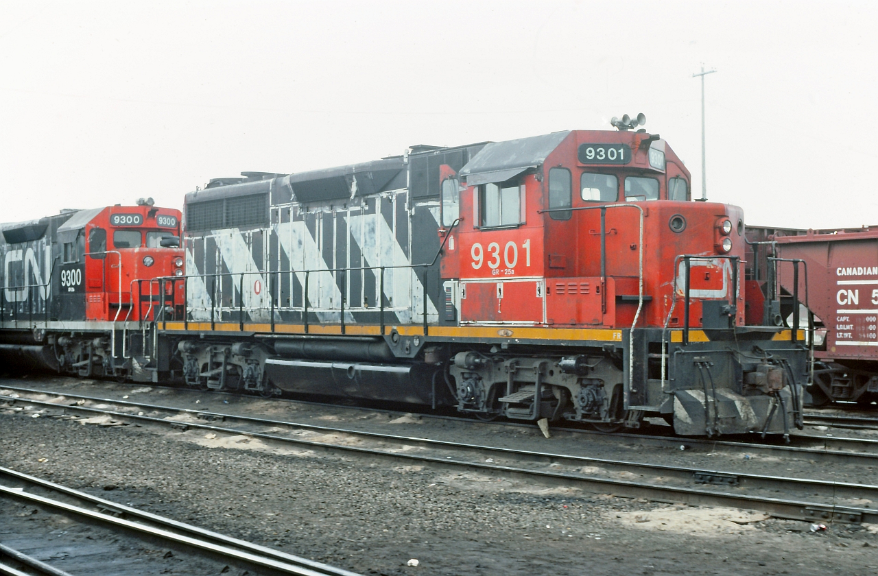 CN 9301 and 9300 on the shop track at Calder Yard, now known as Walker Yard. Bell and classification lights missing on the 9301 as well as being dead and drained, obviously not fit for service. My info is that the 9301 was originally numbered CN 4001 and one of two GP35's that CN had. Any info about these units greatly appreciated.