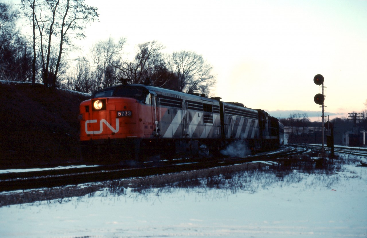 "I'll be home for Christmas"...or on my way back on Boxing Day. As dusk falls at Bayview, CN train No. 75 eases through behind an FPA4-F9B-GP9 lash-up. As soon as the last coach clears the switches, and the crew confirms that the signal at Hamilton West is "Clear", the engineman will open the throttle up of this 15-car train for a sprint to London and Windsor.