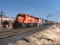 Something new, something old, something borrowed and something blue: a real power-heavy dog's breakfast lashup handles this CP freight heading westbound through Cherrywood on the Belleville Sub, passing the sectionman's toolhouse about to cross Whites Rd. N. on its way to Toronto. <br><br> CP SD40-2 5755 (built in 1975 but in relatively fresh paint from repainting) leads SD40 5500 (their first SD40), a pair of leased Conrail GP38's including one in blue and one in PC black (judging by the smoke, CP's getting their money's worth out of her), another CP SD40-2, a C424, a Chessie-painted B&O GP, another CP C424 and one last blue Conrail GP buried at the rear of the consist. <br><br> <i>Keith Hansen photo, Dan Dell'Unto collection slide.</i>