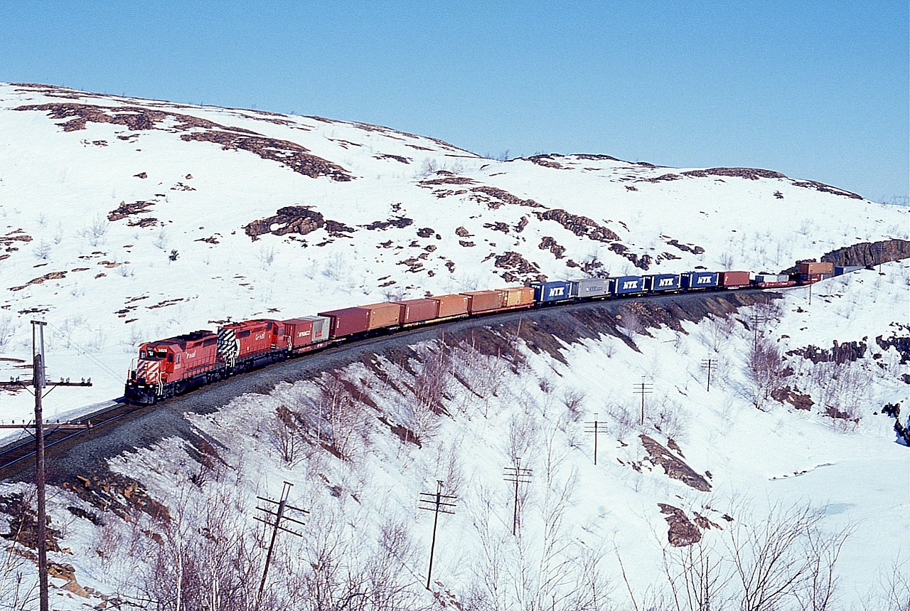Yeah, this was April Fools Day, 1997. Hiking back into this area, I felt like one. This image is taken off the rock at mile 119 PS Sub, close by Baby Lake. And it is frozen.  Quite the scenery around the Great Sudbury area, so barren back then it was actually nice.  Here, CP 5826 and 5998 make their way south, about 2 miles out of Romford.