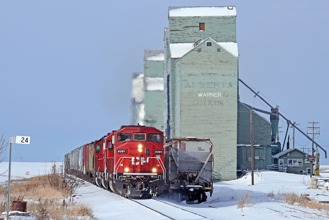 I was fortunate to have stumbled upon CP's A08 assignment to Coutts, AB / Sweetgrass, MT., and a connection with the BNSF, as I was myself headed to the border crossing this day. CP 6261, 6309, and 6251 lead the way past the surviving wheat kings at Warner. 1309hrs.