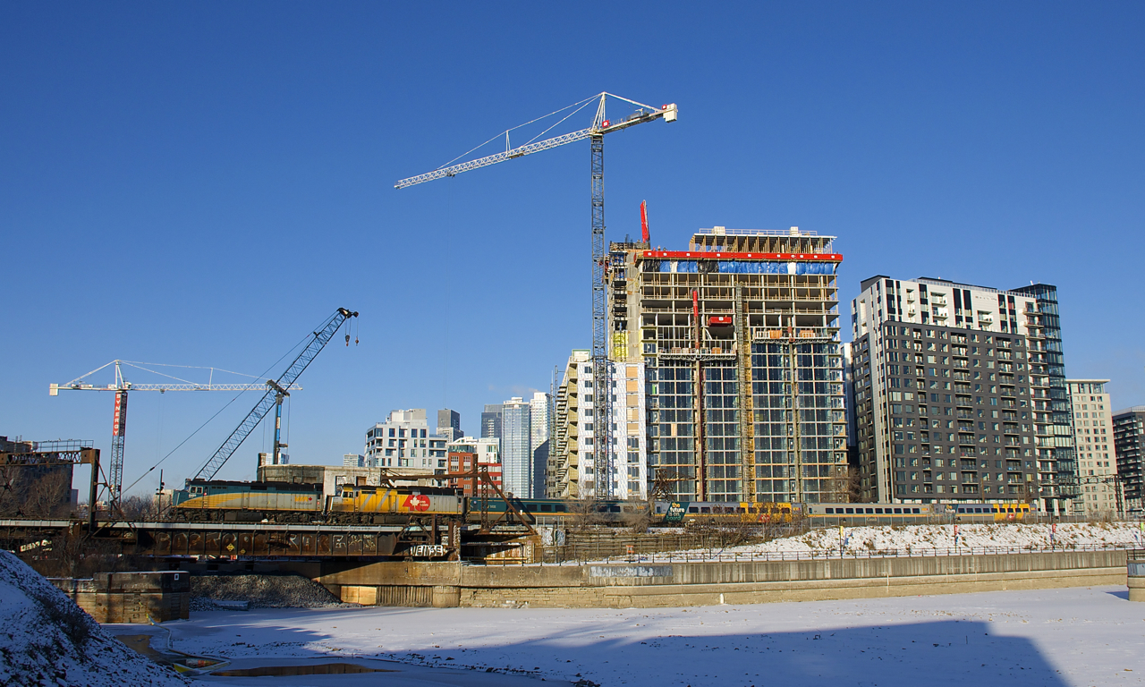 VIA 63 has unwrapped VIA 6451 and wrapped VIA 6416 as it passes the Peel Basin five minutes after leaving Central Station. Behind the power are four LRC cars, including two that are wrapped.