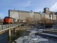 CN 9677 & CN 4724 have just 4 cars to interchange with the Port of Montreal as they pass grain elevator #5 and cross the partly frozen Lachine Canal.