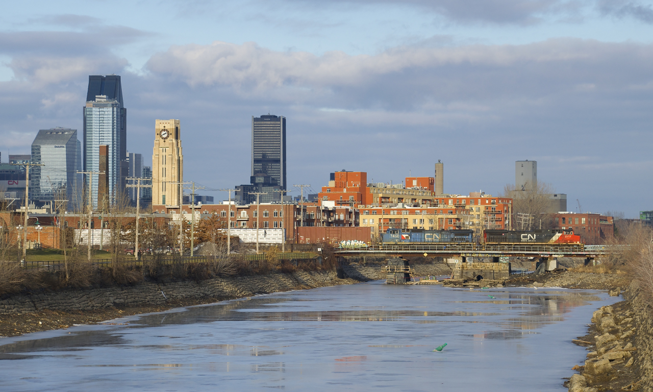 CN X324 has 64 cars to interchange with the NECR in St. Albans, VT as it crosses the Lachine Canal with two Illinois Central units in two paint schemes (IC 2460 & IC 2717) on a mild afternoon.