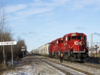 After setting off two GP20C-ECO's for local service at Delson, the crew is getting back onboard; in a few minutes the train will depart Delson for the Lacolle Sub. At left is the advance station sign for St-Constant, a mile to the north of here. Partly visible at right is Stella-Jones Inc., which produces railway ties and utility poles.