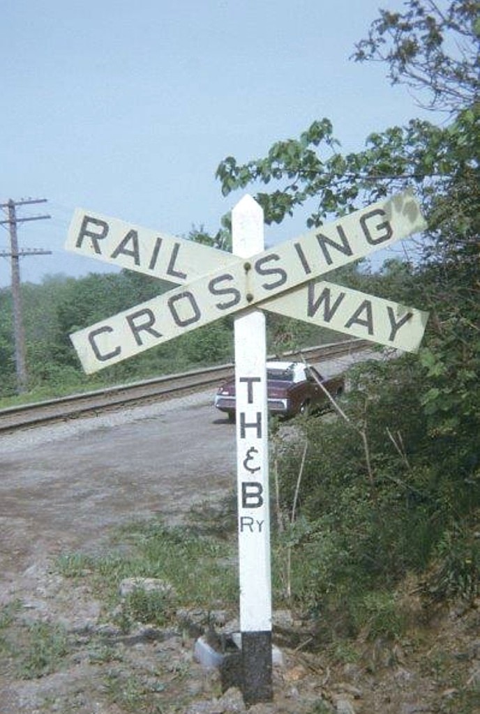 I submitted this little photo just for the nostalgia of it.  I don't think there are any signs 'out in the wild' with the old TH&B lettered on it, seeing the road has been gone around 30 years. This little souvenir was shot at the DeWitt Rd crossing where the road snakes up the mountain.  Thats my old 1971 Cougar in the picture. I should have moved it.