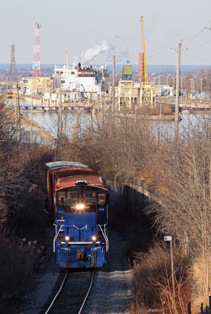 After dropping four loaded box cars at WP Warehousing on the north side of the CN Grimsby Sub, Trillium brings the empties up the hill on the Thorold Sub/Spur with leased power GMTX 340. This recognizable location, made famous by the steep grade and the Welland canals twin flight locks as a backdrop have been captured a number of times by other Railpictures photographers including Arnold Mooney, Geoff Elliott and Doctapinklaces.