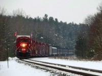 On a grey day, the Holiday Train comes out of the curve and is about to pass the Midhurst station sign.