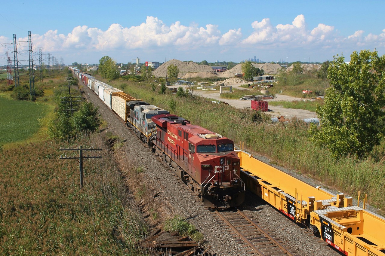 With afternoon thunderstorms firing up to the west, CP 140 meets CP 235 with new wellcars from National Steel Car at East Walkerville. A Kansas City Southern de México AC4400CW in the original grey ghost paint was trailing. The skylines of Windsor and Detroit are visible in the background from this overpass.