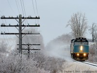 Ice covered insulators glow in colours matching the blue of VIA's 6443 as train 84 blasts by Mosborough toward Toronto after an overnight storm.