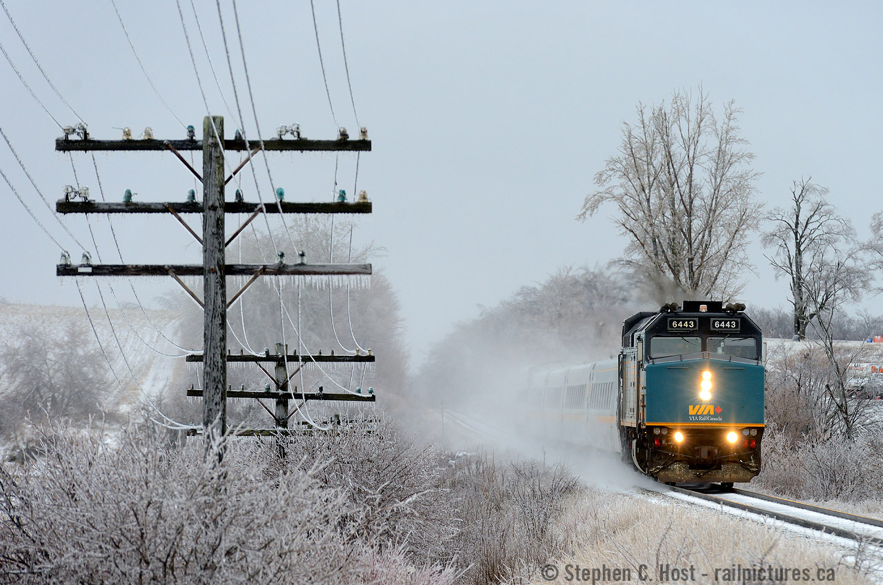 Ice covered insulators glow in colours matching the blue of VIA's 6443 as train 84 blasts by Mosborough toward Toronto after an overnight storm.