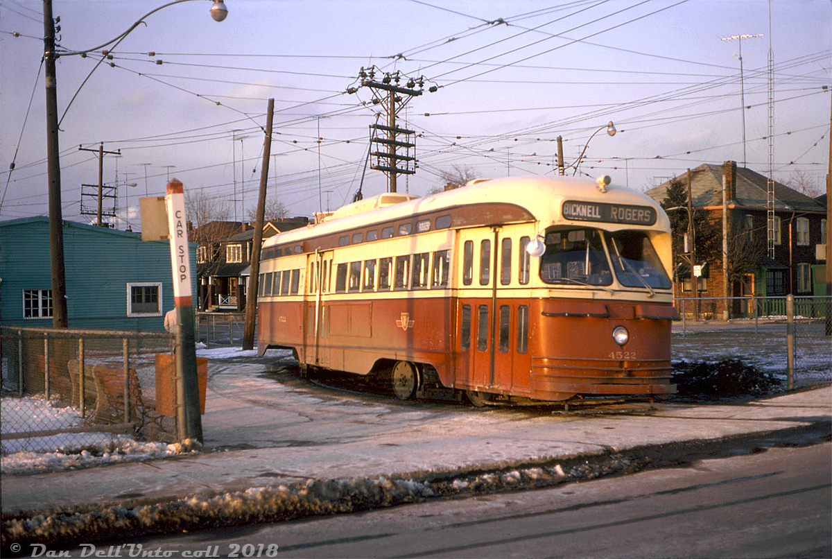 Long Fall evening shadows are cast on TTC PCC 4522, operating on the Rogers Road route about to depart Bicknell Loop and head back east. The Rogers Road streetcar route ran from Oakwood Loop (or St. Clair Subway Station during rush hours) north on Oakwood Ave., west on Rogers and looped here at Bicknell Loop at the NW corner of Rogers & Bicknell, across from a Dominion grocery store and their large distribution warehouse (that had a rail siding off the CP MacTier Sub, and was once home to munitions manufacturer York Arsenals during WW2). The 4500-series A8 PCC streetcars, the newest in the fleet at the time, were commonly assigned as the Rogers route was operated out of Wychwood (St. Clair) Carhouse.  By this point in time, long shadows were also cast over the existence of the Rogers Road streetcar itself, and less than a year's time it would cease to exist altogether. Part of the reason (noted in Sean Marshall's Spacing.ca post on the route) was the town of York didn't want to spend the extra money including new streetcar track when repaving some of its deteriorating roads (looking at photos taken during the final days, parts of Rogers Rd. were looking quite shabby), and part of the reason was after reversing its decision to phase out all streetcars over the next few years, the TTC was short of streetcar equipment to operate its routes until new cars could be designed, ordered and built. Thus, the final day of streetcar services on Rogers Rd. was July 19th 1974, followed by replacement with with a branch of the Ossington trolleybus route.  Original photographer unknown, Dan Dell'Unto collection slide.