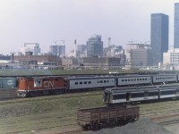 A Tempo consist backs towards Union station from Spadina.  I'm guessing it's backing up from the exhaust.  Lots of cranes at work on the Toronto skyline, and I love the old baggage cars!