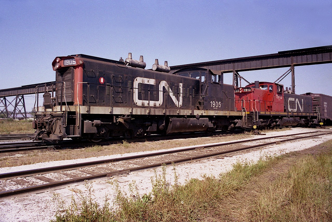Beautiful afternoon just over 42 years back while on my way West, I stopped to check for railroad action in Thunder Bay. This was when I first learned there is always action around TB !!!  CN 1905 and 1913, a pair of GMD-1s, work a cut of cars down by the south end of Port Arthur yard.
The 1905 was sold to National Railway Equipment and the 1913 was rebuilt to CN 1402 in 1989.