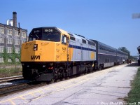 The joint VIA-Amtrak International makes it station stop at Kitchener Station to take on a load of passengers waiting on the platform, operating westbound from Toronto Union Station to the USA over CN via Guelph/London/Sarnia routing. VIA F40PH-2D 6426 up front leads a consist of three Amtrak Superliner cars. A variety of Amtrak passenger equipment operated on this route in later years, ranging from Amfleets to Horizon cars to Superliners (and similar ex-ATSF "Hi-Level" cars) and even some of the old Metroliners converted to coaches showed up once in a while. In addition to VIA F40's, Amtrak P32-8BWH, F40PH and P42DC units were typical of the power that could show up in the years leading to the train's demise in 2004.<br><br><i>Gord Taylor photo, Dan Dell'Unto collection</i>