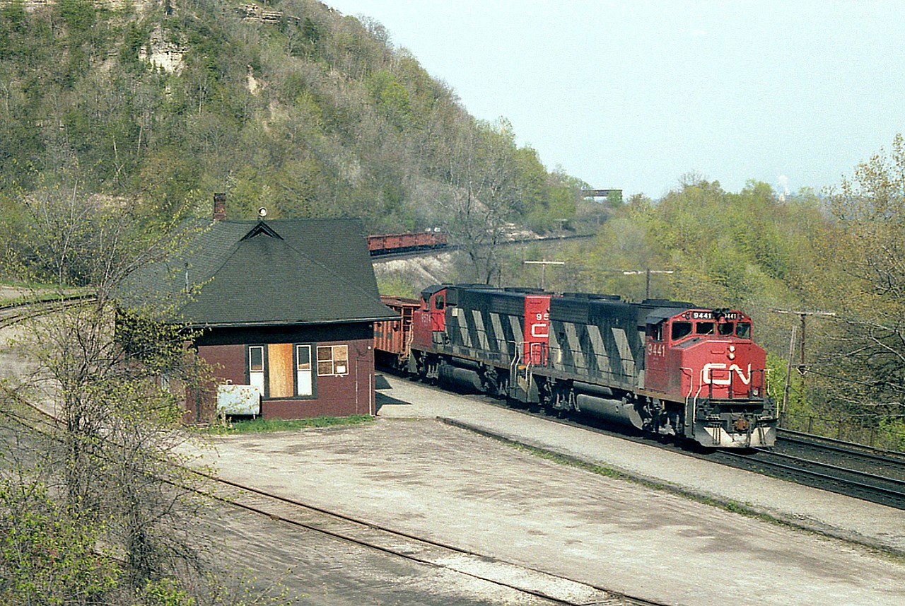 Something about Dundas back in the days of the station kept my crank turning. Here is a pair of wide cabs and a ballast train west. Nice old station. Canada Crushed Stone structure in the background below Dundas Peak. Add some nice soft spring green under a blanket of sunshine and it adds up to a beautiful day to be out. Pity it all is no more.
Amazing how massive the CN widecab fleet once was. CN 9441 went to Alstom in 2001, and 9574 is still slaving away on the CN roster. The GP40-2(W) fleet has whittled down from 278 to just 59.