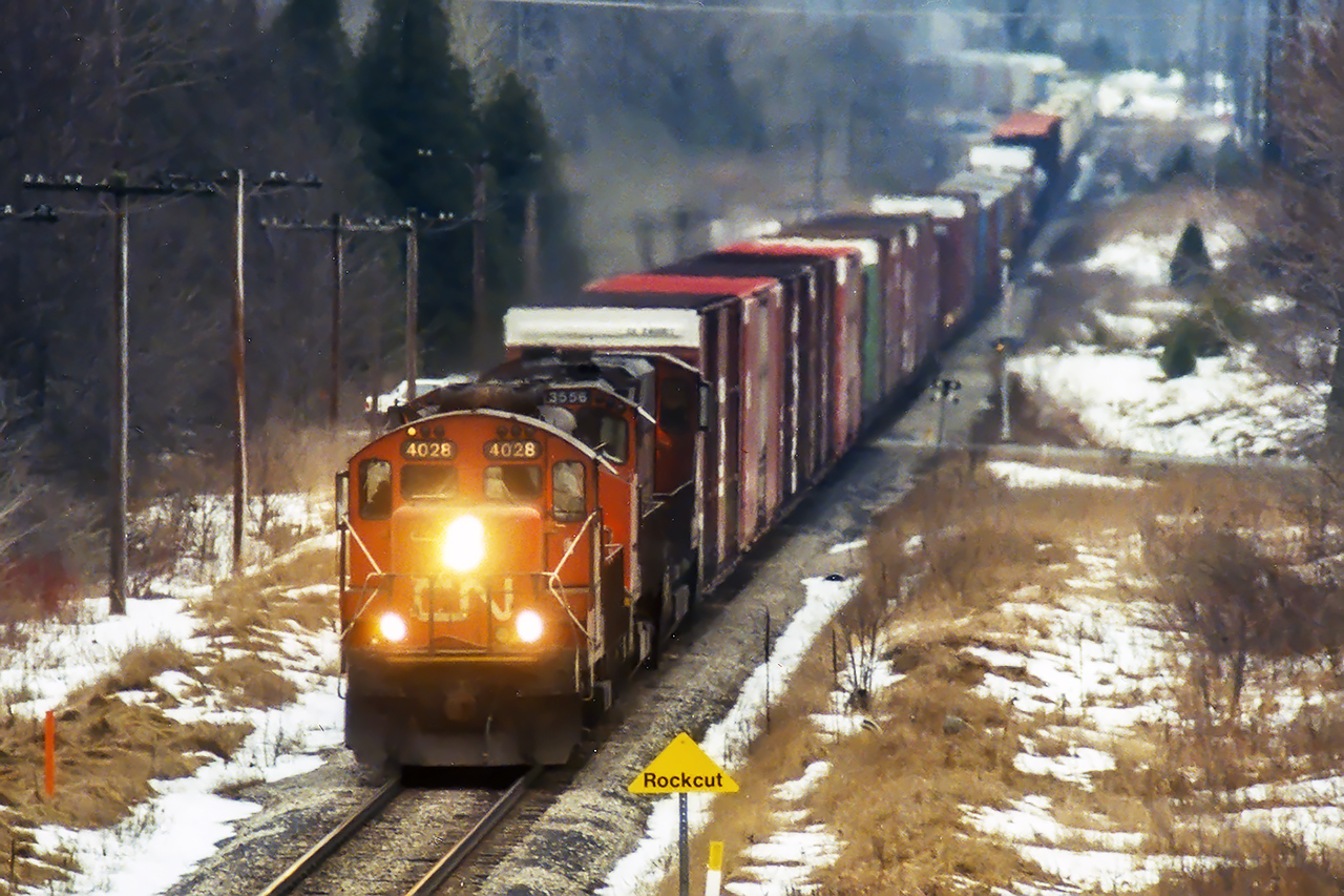 2 M420's and a GP9U leader provide a lashup that only CN could create in the mid 1990's., The high cubes up front haven't been part of the train for years, but the block of salt on the tail end is still a staple.