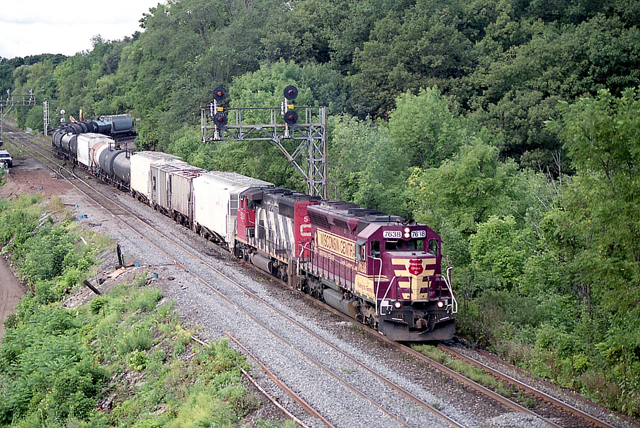 With Wisconsin Central being absorbed into CN, it was becoming increasingly difficult to see WC paint any more, so it was nice to see one on the lead of #390. Trailing unit is CN 5291. An added bonus was the WC 7638 is in Operation Lifesaver paint. 
The transformation of the area for the third track going in for GO services is apparent on the extreme left, one can just make out a construction laneway as work is under way to shore up the terrain at waters' edge.