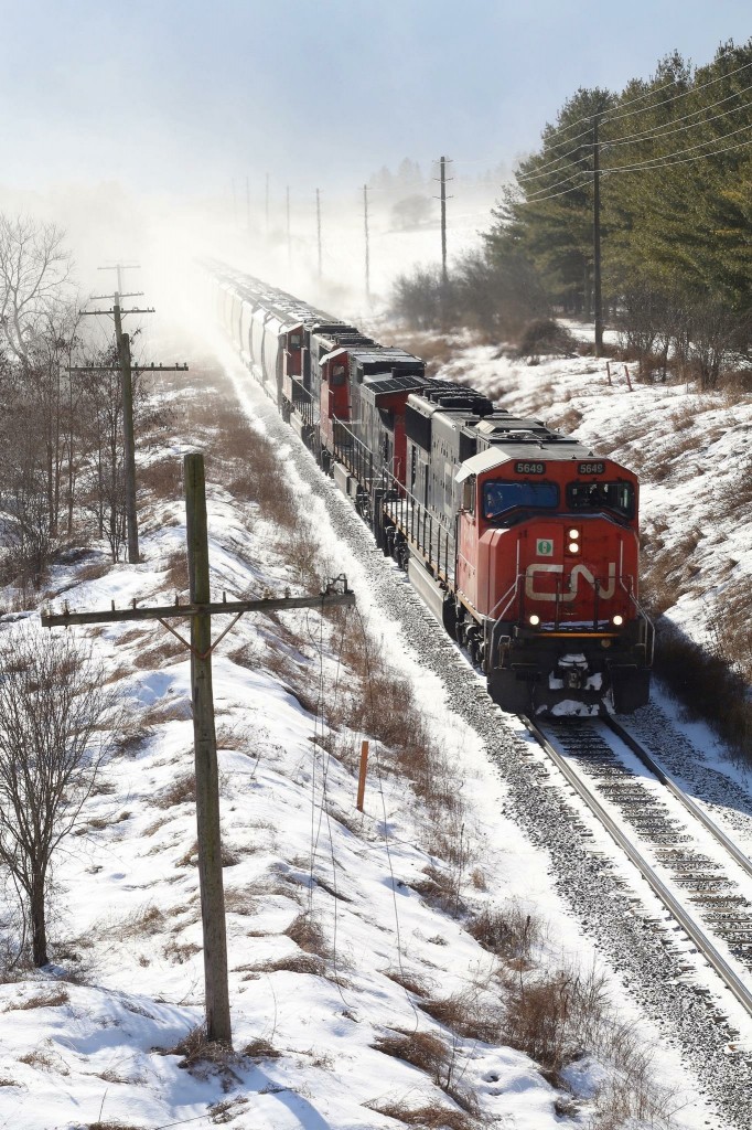 I’m not a big fan of shooting into the sun but I couldn’t resist the rare chance to photograph CN 431 in daylight today as it races away from fast approaching lake affect snow squalls just east of Guelph. Today’s consist is a pair of SD75’s bracketing a Dash 9 as the train is about to duck under Jones Baseline Road.