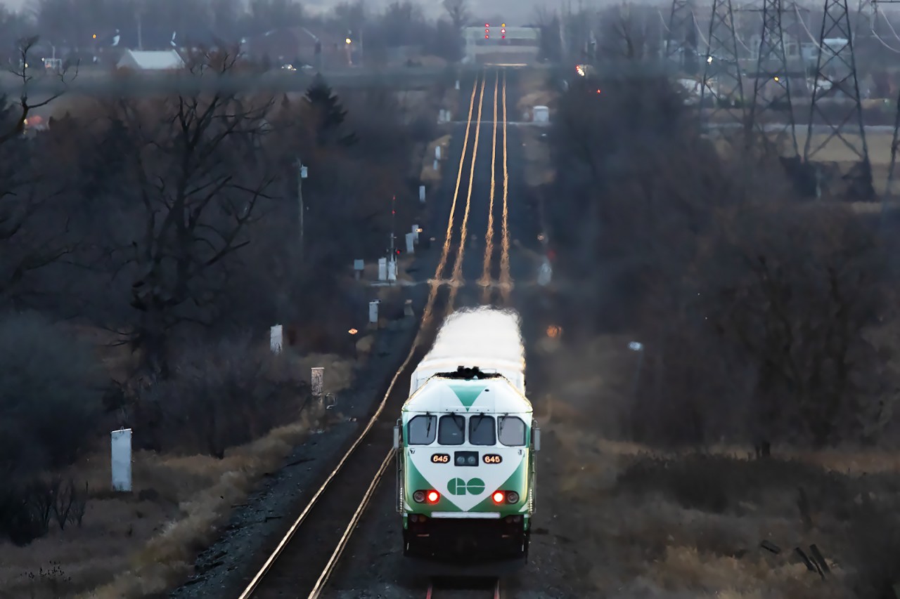 Seen from the Trafalgar Road bridge, the second of the evening GO trains charges into the Hornby Dip preparing to settle in for the weekend. The little cluster of lights to the right of the rails is the layover yard where the first train is being put to bed.