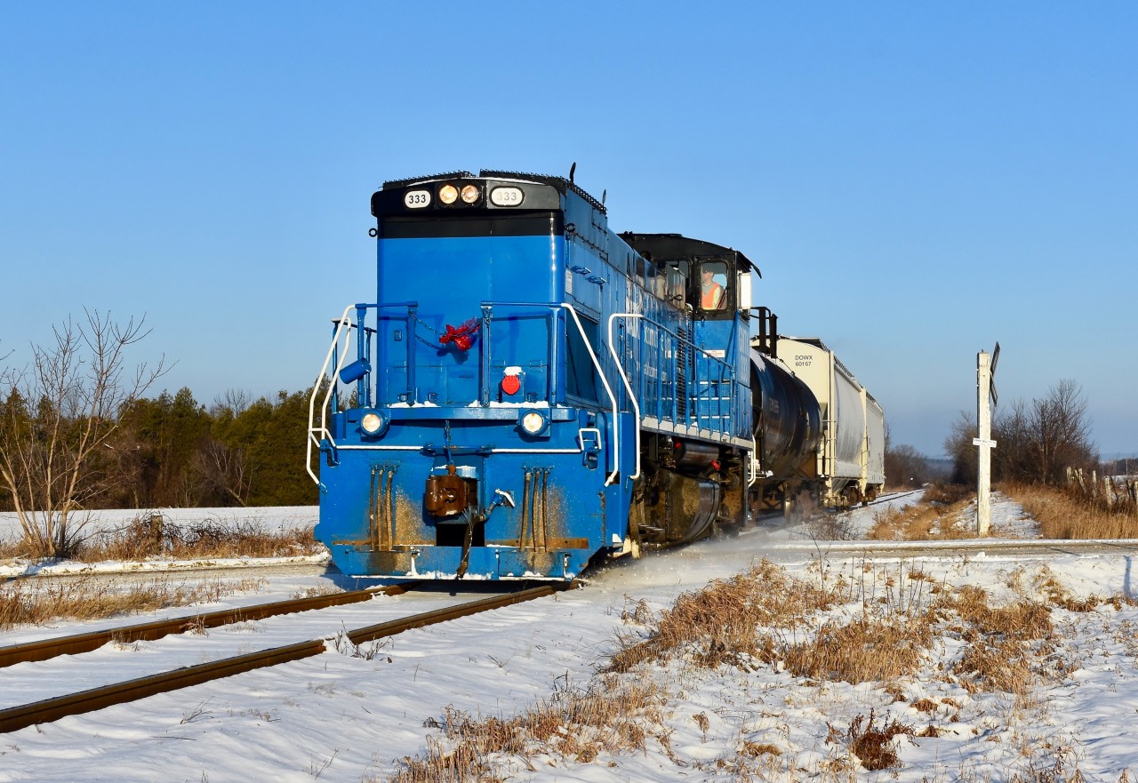 Pushing over the slightest snowhill (previously made by a snowplow) and creating a bit of snow dust, GMTX 333 crosses over Station st in Caledon as it makes its southbound trip to Mississauga on a beautiful sunny winter morning. Time was 09:09