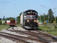 On a sunny June morning, the BCRY crew has coupled the power to two hoppers and is about to depart the yard at Utopia and head to Barrie for the day.  In the background a northbound Canadian Pacific intermodal train is silently crossing the diamond.