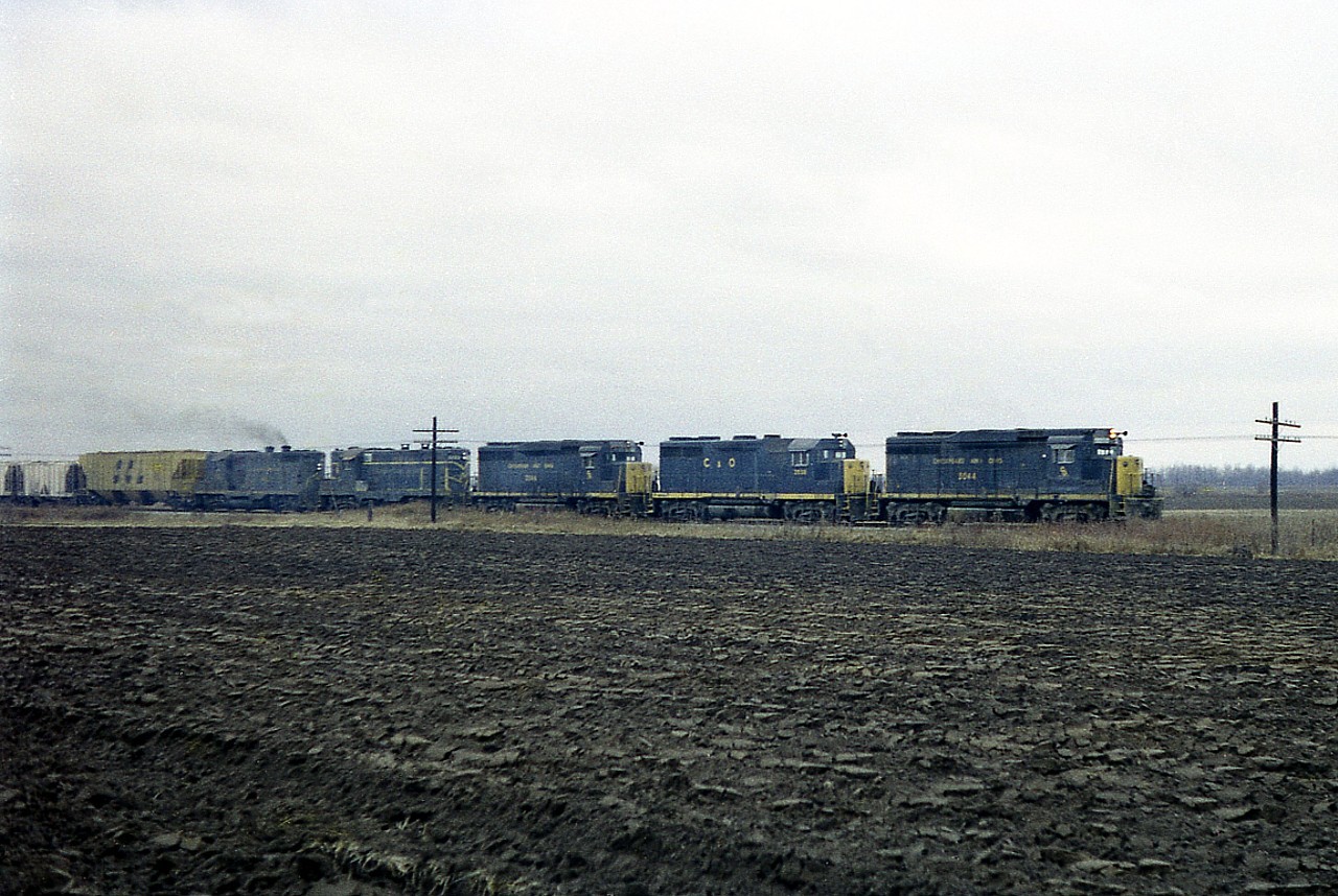 Rough image taken on a dull November day many years back, but this shot of C&O eastbound approaching what I think was Mull Rd; just out of Blenheim, shows a number of 'paint variants' on the old C&O locomotives. The freshly turned muddy field sure doesn't bring any brightness to the image. Units are C&O 3044, 3538, 3046, 5753, and 5708.  The C&O had become part of the Chessie system 4 years previous.