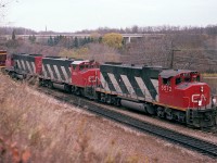 In what would be considered standard fare for back in the day, a westbound GP38-2 leads a couple of GP40-2s off the Oakville Sub and onto the Dundas, as seen from the hillside at the Royal Botanical Gardens before all the foliage wiped out this as a shooting location.  Units are CN 5572, 9661 and 9543. I also noted the car count, which was 47, and the caboose, #79411.