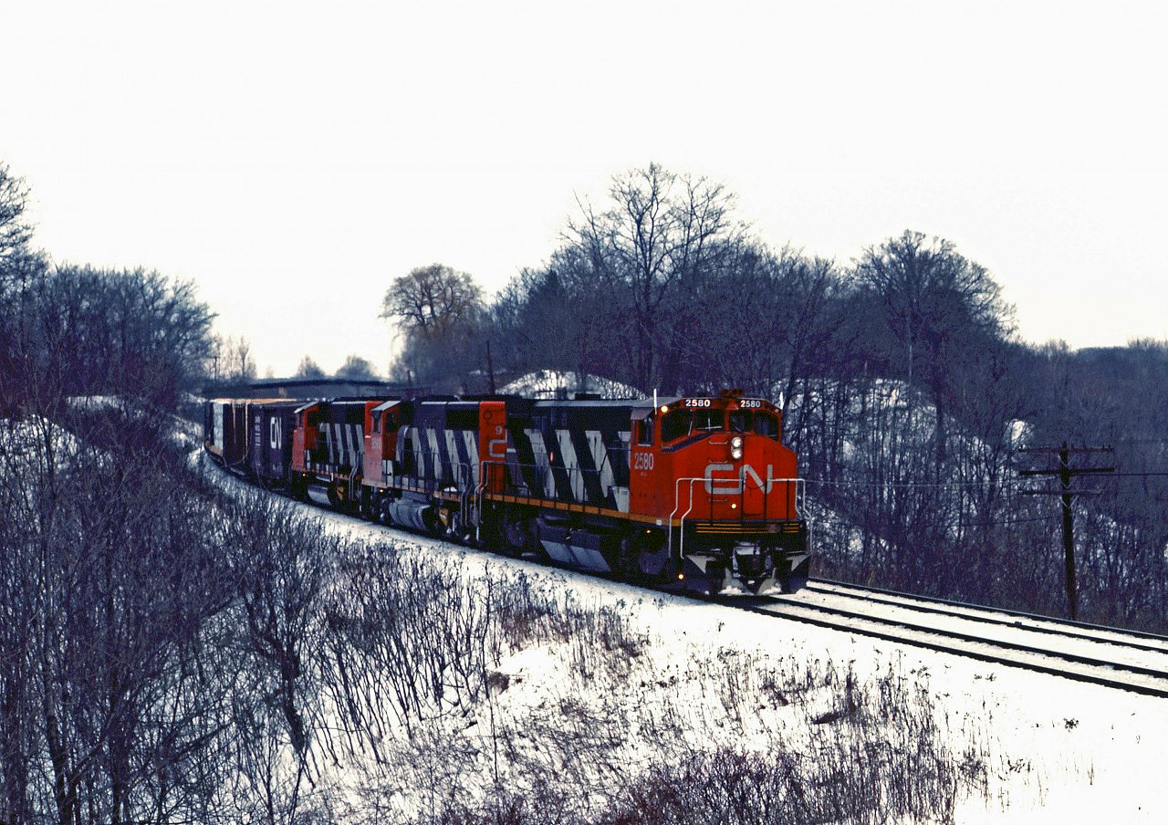 A CN westbound drifts down the curve into Bayview on a dull day in February 1985. Leading the train is a rare (only 10 built) HR412, MLW's successor to the M420W.