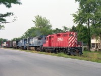 Around when this photo was snapped, CP was leasing an amazing 200+ locomotives. Included were a handful of Conrail C40-8s. I saw very few of them and apparently they were not on the property very long. All returned not long after I caught CP 8247, CR 6049 and 6032 bringing CP #521 from the USA en route to Toronto. In this scene the train is rolling parallel to Elizabeth Place, a short roadway just south of Queen St., which is protected by overhead signals as seen in the background. Time is late day, after the dinner hour.  These were "heady" days for the fans.