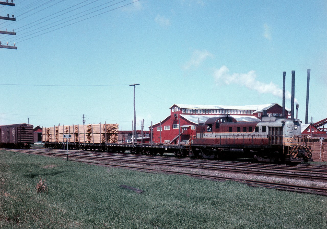 On May 12, 1958, Stephan Delmonte (Del) Rosamond  is trackside at the same location across from Consolidated Paper and Lumber Company mill in Pembroke, ON.  The eastbound wayfreight is working in the yard, this time with Montreal Locomotive Works – built diesel-electric roadswitcher RS-3 No. 8434.  The locomotive is just over 4 years old, having entered service in April 1954.  Del's picture suggests that the crew, has just lifted three loads of rough sawn pine boards off the mill's sorting table track, is about to set-off the loaded flatcars in the yard, and then return to the sorting table track with the two empties so that further loading might continue.  Of note, the sorting table is 200 feet long and allows for the spotting of 5 rail cars at a time.  Each flatcar, on average, can be loaded with 8000 board feet per diem.  Available information suggests that the lumber on the flatcars is destined to be delivered to either the Pembroke Shook Mills – where it will be piled, or to the Barrands Planning Mill where it will be planed and then reshipped to customers in boxcars.


Noteworthy also is the fact that Del is observing local railroading on the CPR as a strike by the Canadian Brotherhood of Locomotive Firemen and Enginemen against the Company enters its second day.  It would be called off one day later on the 13th of May, just three days after being initiated.  This is the second walk-out by CPR firemen – the first being nine days in January 1957- in protest to the elimination of 2800 yard and freight service firemen jobs brought on by the introduction of diesel-electric locomotives and the ensuing technological change.


The current job action by the Brotherhood was initiated after a Royal Commission concluded earlier in the year, that the elimination of the locomotive firemen positions would not endanger public safety.  The decision made in favour of the Company is regarded as a watershed moment in Canadian railway history.



Digital scanning, research and narrative courtesy of Raymond Farand.