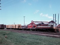 On May 12, 1958, Stephan Delmonte (Del) Rosamond  is trackside at the same location across from Consolidated Paper and Lumber Company mill in Pembroke, ON.  The eastbound wayfreight is working in the yard, this time with Montreal Locomotive Works – built diesel-electric roadswitcher RS-3 No. 8434.  The locomotive is just over 4 years old, having entered service in April 1954.  Del's picture suggests that the crew, has just lifted three loads of rough sawn pine boards off the mill's sorting table track, is about to set-off the loaded flatcars in the yard, and then return to the sorting table track with the two empties so that further loading might continue.  Of note, the sorting table is 200 feet long and allows for the spotting of 5 rail cars at a time.  Each flatcar, on average, can be loaded with 8000 board feet per diem.  Available information suggests that the lumber on the flatcars is destined to be delivered to either the Pembroke Shook Mills – where it will be piled, or to the Barrands Planning Mill where it will be planed and then reshipped to customers in boxcars.
<br>
<br>
Noteworthy also is the fact that Del is observing local railroading on the CPR as a strike by the Canadian Brotherhood of Locomotive Firemen and Enginemen against the Company enters its second day.  It would be called off one day later on the 13th of May, just three days after being initiated.  This is the second walk-out by CPR firemen – the first being nine days in January 1957- in protest to the elimination of 2800 yard and freight service firemen jobs brought on by the introduction of diesel-electric locomotives and the ensuing technological change.
<br>
<br>
The current job action by the Brotherhood was initiated after a Royal Commission concluded earlier in the year, that the elimination of the locomotive firemen positions would not endanger public safety.  The decision made in favour of the Company is regarded as a watershed moment in Canadian railway history.

<br>
<br>
Digital scanning, research and narrative courtesy of Raymond Farand.