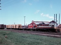 On May 12, 1958, Stephan Delmonte (Del) Rosamond  is trackside at the same location across from Consolidated Paper and Lumber Company mill in Pembroke, ON.  The eastbound wayfreight is working in the yard, this time with Montreal Locomotive Works – built diesel-electric roadswitcher RS-3 No. 8434.  The locomotive is just over 4 years old, having entered service in April 1954.  Del's picture suggests that the crew, has just lifted three loads of rough sawn pine boards off the mill's sorting table track, is about to set-off the loaded flatcars in the yard, and then return to the sorting table track with the two empties so that further loading might continue.  Of note, the sorting table is 200 feet long and allows for the spotting of 5 rail cars at a time.  Each flatcar, on average, can be loaded with 8000 board feet per diem.  Available information suggests that the lumber on the flatcars is destined to be delivered to either the Pembroke Shook Mills – where it will be piled, or to the Barrands Planning Mill where it will be planed and then reshipped to customers in boxcars.
<br>
<br>
Noteworthy also is the fact that Del is observing local railroading on the CPR as a strike by the Canadian Brotherhood of Locomotive Firemen and Enginemen against the Company enters its second day.  It would be called off one day later on the 13th of May, just three days after being initiated.  This is the second walk-out by CPR firemen – the first being nine days in January 1957- in protest to the elimination of 2800 yard and freight service firemen jobs brought on by the introduction of diesel-electric locomotives and the ensuing technological change.
<br>
<br>
The current job action by the Brotherhood was initiated after a Royal Commission concluded earlier in the year, that the elimination of the locomotive firemen positions would not endanger public safety.  The decision made in favour of the Company is regarded as a watershed moment in Canadian railway history.

<br>
<br>
Digital scanning, research and narrative courtesy of Raymond Farand.