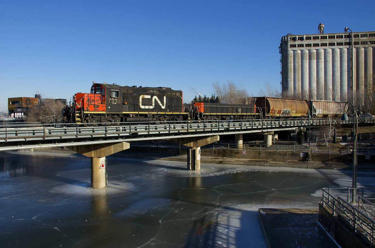 The Pointe St-Charles switcher has just two cars for the Port of Montreal as it crosses the frozen Lachine Canal with CN 7233 & CN 227 for power.