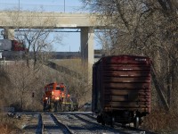 After putting a single boxcar in the siding, the power runs around the car before shoving it into the Kruger Plant located at the end of the Turcot Holding Spur. In the background is the rapidly changing Turcot interchange, with the new, lower lanes already in use, and the higher and older lanes soon to be demolished.