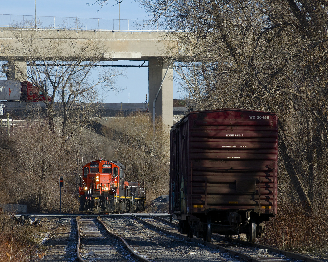 After putting a single boxcar in the siding, the power runs around the car before shoving it into the Kruger Plant located at the end of the Turcot Holding Spur. In the background is the rapidly changing Turcot interchange, with the new, lower lanes already in use, and the higher and older lanes soon to be demolished.