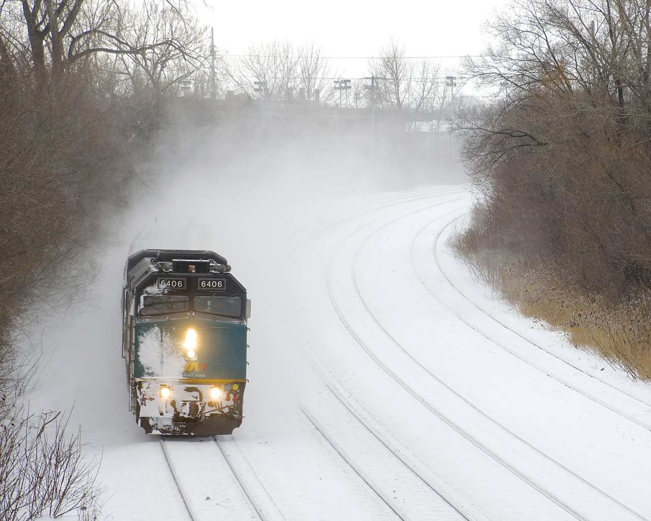 Snow-covered VIA 6406 leads VIA 34 from Ottawa around a curve as it heads east.