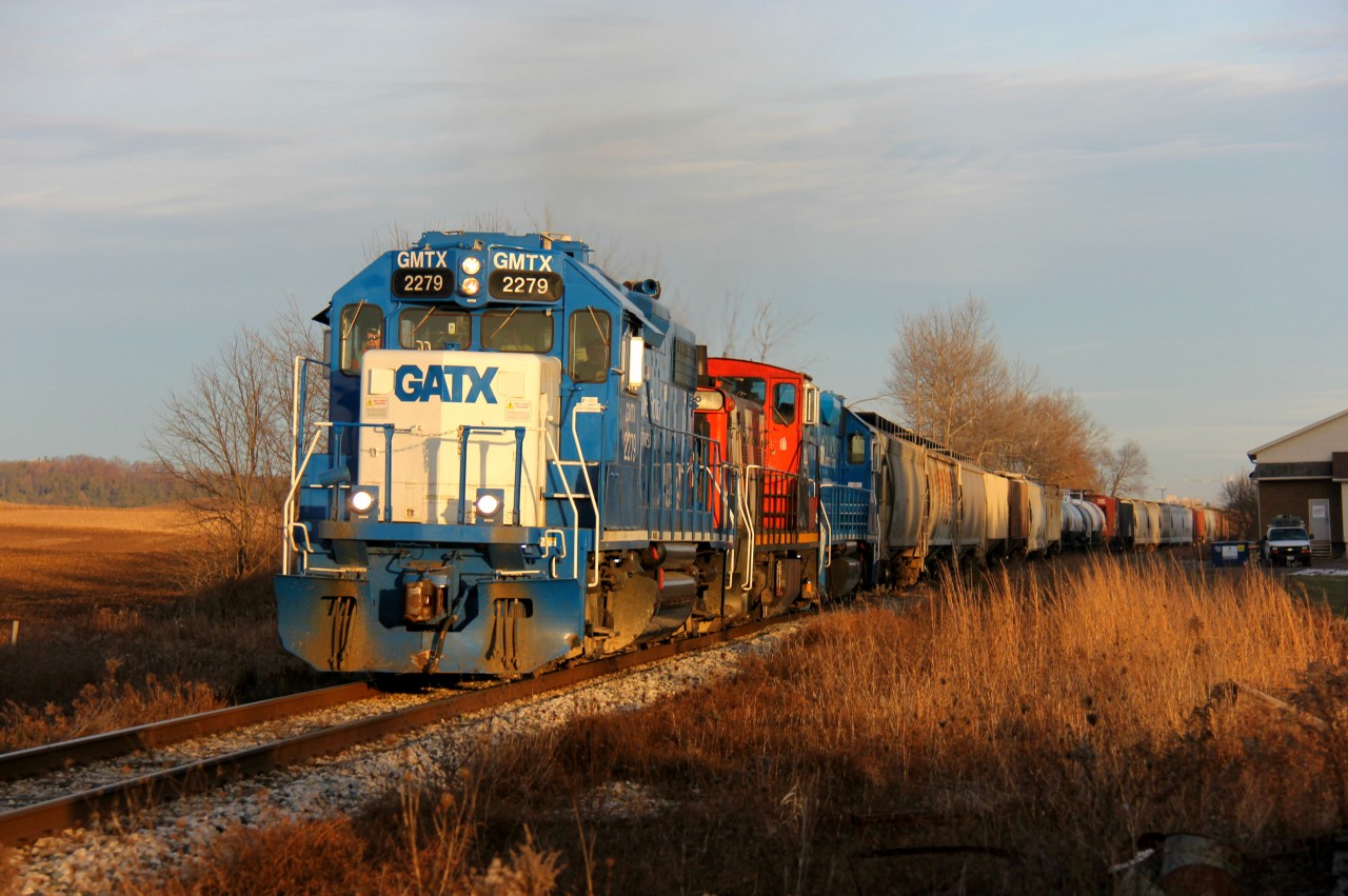 The chase was on. After catching this train slowly depart Kitchener with a lengthy train and muted light, I decided to get on Hwy. 7/8 and head west to Petersburg and Baden when the sun sank below the stubborn clouds earlier. CN L568 is pictured on the approach to Notre Dame Dr. in Petersburg west of Kitchener with GMTX 2279, CN 1444 and another GMTX. Its next stop was the Nachurs Alpine facility off Nafziger Road between Baden and New Hamburg.