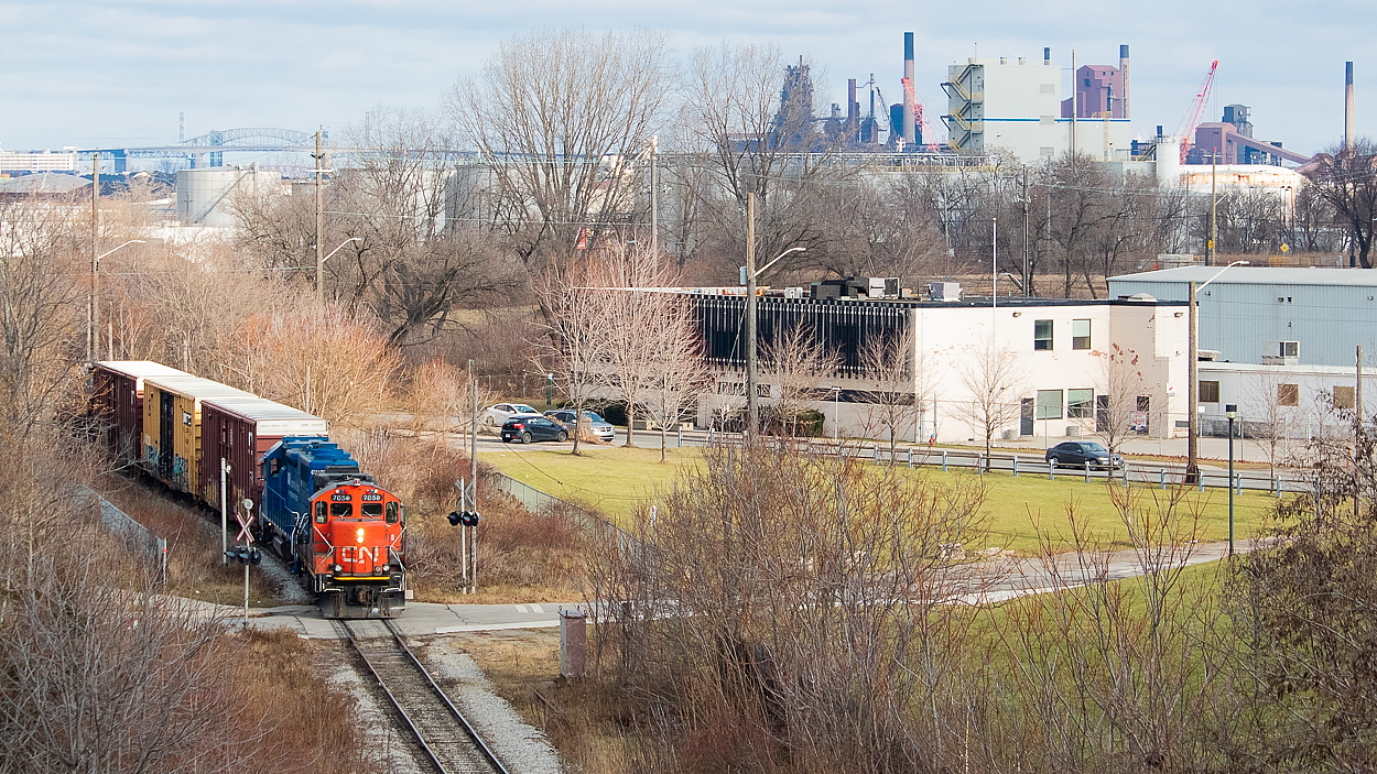 This is an angle I have done before, even recently with a smoky 4003. However, I had yet to have a good opportunity at shots of CN since they assumed Hamilton operations from SOR on December 14 and this is one of the more noteworthy angles the N&NW has to offer with respect to stamping the location as Hamilton. Here, the 07:00 yard job has finished its work down the hole for the day and is led back to Stuart Street by 7058 - a beltpack-equipped unit. For those wondering, all of power sets for CN in Hamilton so far have been beltpack-equipped. The three boxcars upfront are from Parkdale Warehousing, and a lone tank brought up the rear. I am still adjusting to the fact that I won't find SOR switching out there in the north end anymore.