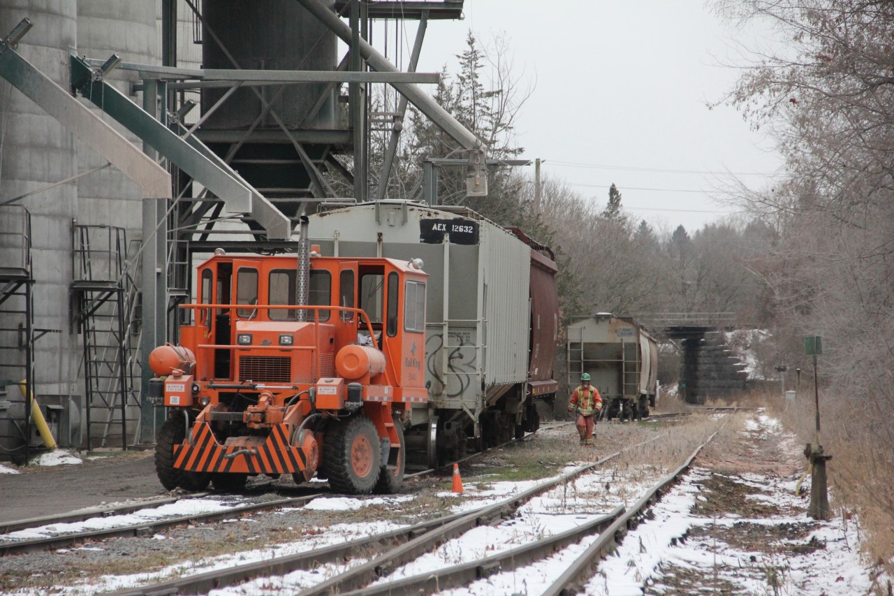 Employees at the P&H Tri county mill have just spotted and tied down two hoppers for loading. Once there new track mobile is clear of the rails loading will begin. The siding has a 7 car capacity. Two loads have been pushed to the south. The bridge in the background is the CN Kingston sub. This is at mile 32.18 on CN,s old Marmora sub. The last existing portion of the line from Marmora to Trenton. CN normally switches the mill on Thursdays and Sundays. Access to the line is from a connecting track just east of the Via station at Quinte west/ Trenton.