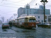 A snow/sleet mix appears to be falling on this mid-April (!) Saturday, as passengers crowd the streetcar platforms at the corner of Dundas Street West and Bloor Street West waiting to board a streetcar and get out of the weather. TTC A-13 class PCC 4738 (a former Birmingham car purchased secondhand) leads the pack signed up for the Dundas route, turning from northbound Dundas to westbound Bloor on a diversion west to Park Loop (once located at the north end of High Park off Bloor) during construction of the nearby Dundas West subway station on the yet-to-be-opened Bloor Danforth line. <br><br> Other photos taken by Mr. Bromley that day show some streetcars (probably King cars) were still looping at nearby Vincent Loop; the diversion here was apparently just the Dundas cars on the Runnymede branch only going as far as Bloor and diverting west. Puddicombe Motors is pictured on the right at the southwest corner of the intersection (a large local Ford/Mercury dealer in the area). And, note that stylish 1960's Buick on the left!<br><br><i>John F. Bromley photo, Dan Dell'Unto collection slide.</i>
