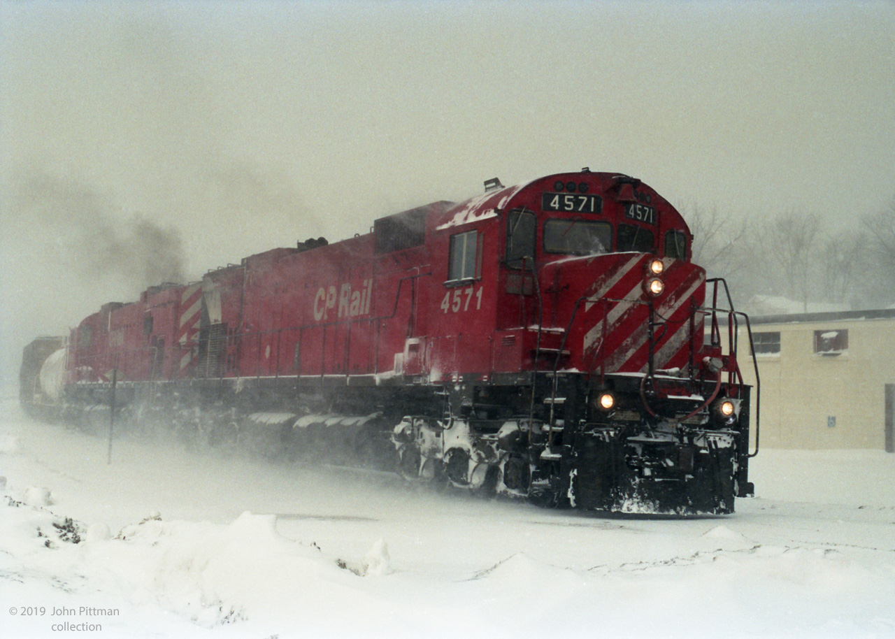 A pair of clean "Big Alco" MLW M630's CP 4571 (multimark) and CP 4562 (red & stripes) lead a CP freight train round a curve in harsh-looking winter conditions on 24 January 1992. I believe the photographer was close to his home in London ON, considering the weather, and my other images by him. Adjacent frames show a grade crossing. 
His camera date stamp feature imprinted the film, so date should be exact.