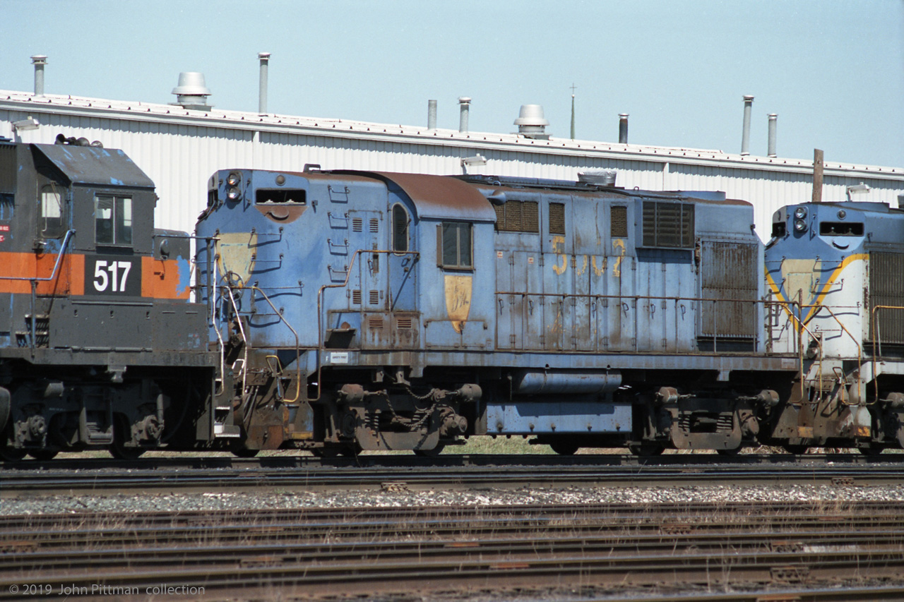 DH 5002 (Alco RS-11) is the first of five retired D&H locomotives following the active units of a westbound CP train, lead by SOO 763 (SD40-2) and HATX 517 (GP40-2). Photographed toward the west end of CP's Quebec Street Yard, I believe they were en route to National Railway Equipment (NRE) in Silvis IL, where most of them would be scrapped. Date is best estimate based on available information.