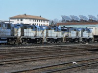 Five retired D&H locomotives follow behind the active units on a westbound CP train, lead by SOO 763 (SD40-2) and HATX 517 (GP40-2). Photographed toward the west end of CP's Quebec Street Yard, near the landmark military heritage T-Block building.<br>D&H 5000-5011 are RS-11, while D&H 5012-5023 are RS-36. Other than high/low short hoods not much visible difference, all have Alco 251 V12 prime movers of 1800 HP. Blue DH5002, then DH50??, DH5023, DH5017, DH5009 with a piggyback trailer on flatcar (TOFC) beginning the train.<br>CP acquired the D&H in 1992; online sources indicate that these engines were sold to NRE in 1993, with most of them scrapped. Looks to me like they are en route west to NRE in Silvis IL.<br>DH 5017 was saved, it is running in fresh D&H colours on the Delaware & Ulster tourist railway of Arkville NY (as of 2018).