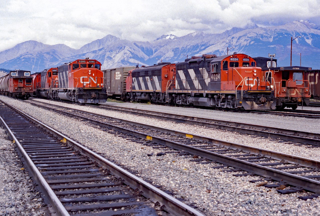 An old time shot of Jasper yard.  Taken in 1987 probably August as it would have been a vacation shot.  We see GP9u CN 4024 with F7Au CN 9159 and beside them caboose CN 79519.  The other grouping is SD40-2(W) CN 5280 SD40 CN 5165 and beside them caboose CN 70074