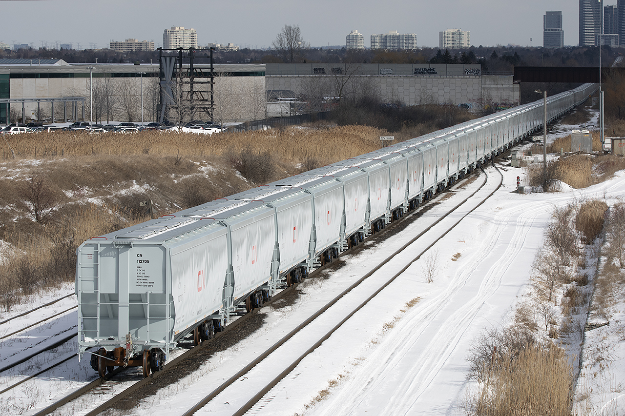 A "clean" unit train...not quite. New hoppers make their first trip west.